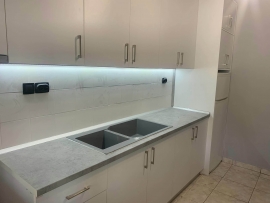 Επίπλωση κουζίνας από λευκό βακελίτη και πάγκο από βακελίτη τύπου "Τσιμέντο"